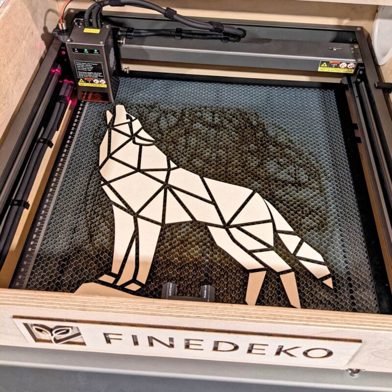 Laser-Cutter fertigt Low-Poly-Wolf aus Pappelholz – FineDeko Werkstatt, moderne Holzdekoration mit Präzision und Leidenschaft.